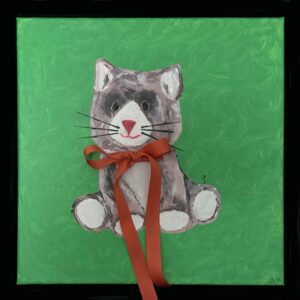 En lille person rækker armene op mod en blød plyskat med rød sløjfe.