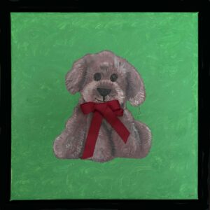 En lille person hænger legende i øret på en blød plyshund med rød sløjfe.